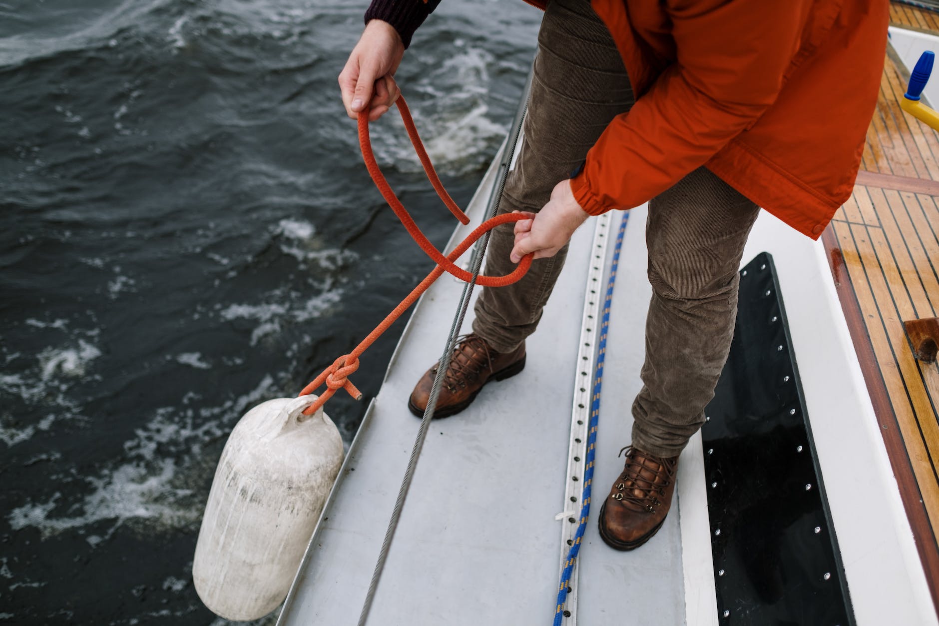 a person in red jacket holding the rope of a white buoy